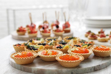 Photo of Many different tasty canapes on white wooden table, closeup