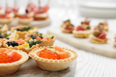 Photo of Many different tasty canapes on white wooden table, closeup