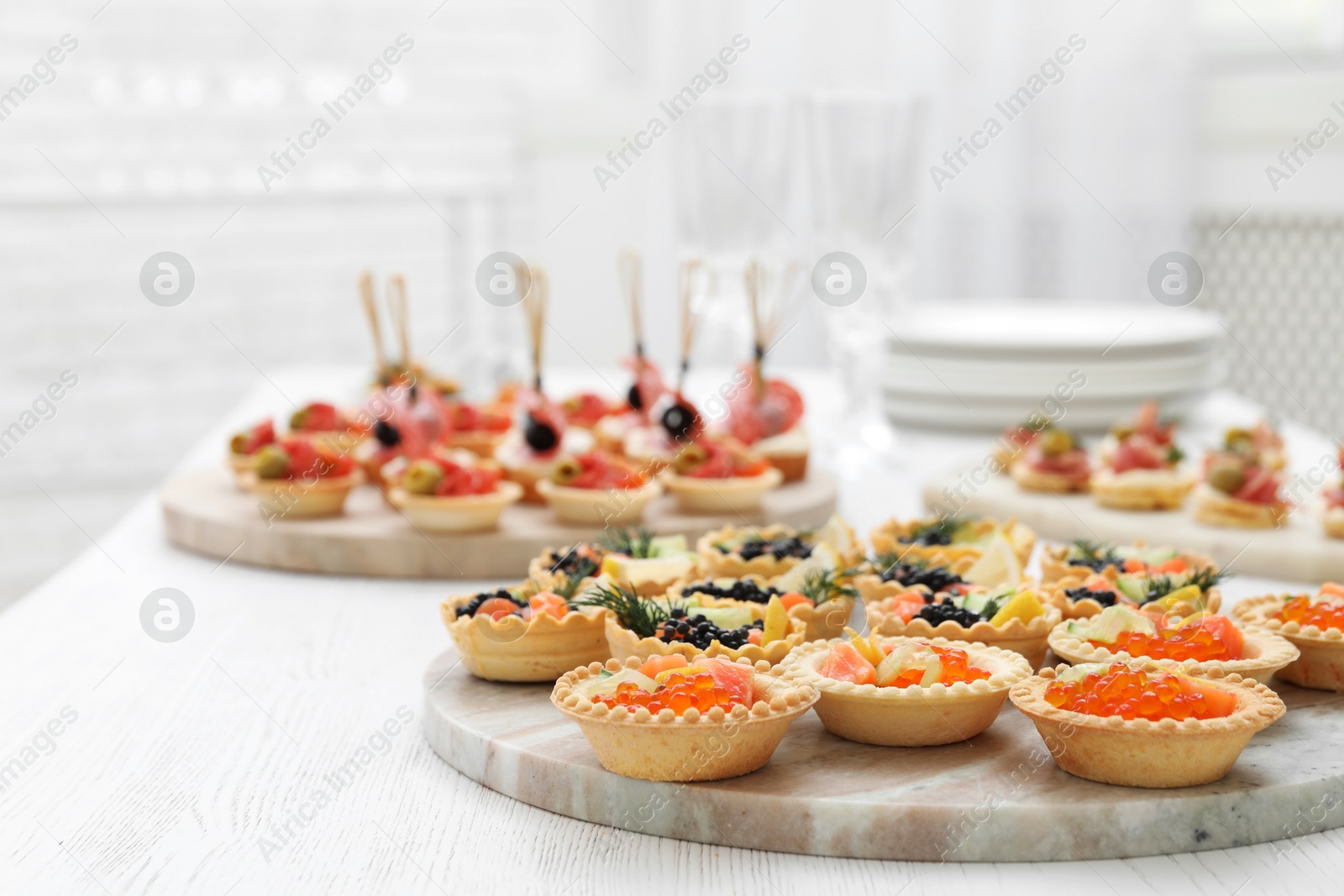 Photo of Many different tasty canapes on white wooden table, closeup