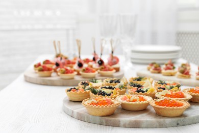 Photo of Many different tasty canapes on white wooden table, closeup