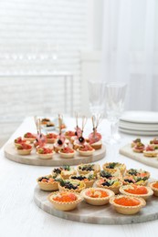 Photo of Many different tasty canapes on white wooden table, closeup