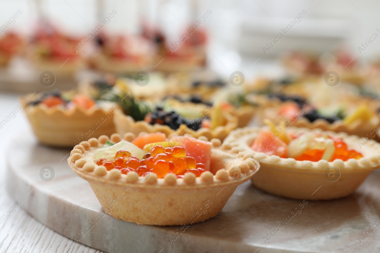 Photo of Many different tasty canapes on white wooden table, closeup