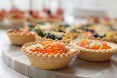 Photo of Many different tasty canapes on white wooden table, closeup