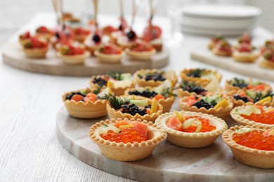 Photo of Many different tasty canapes on white wooden table, closeup