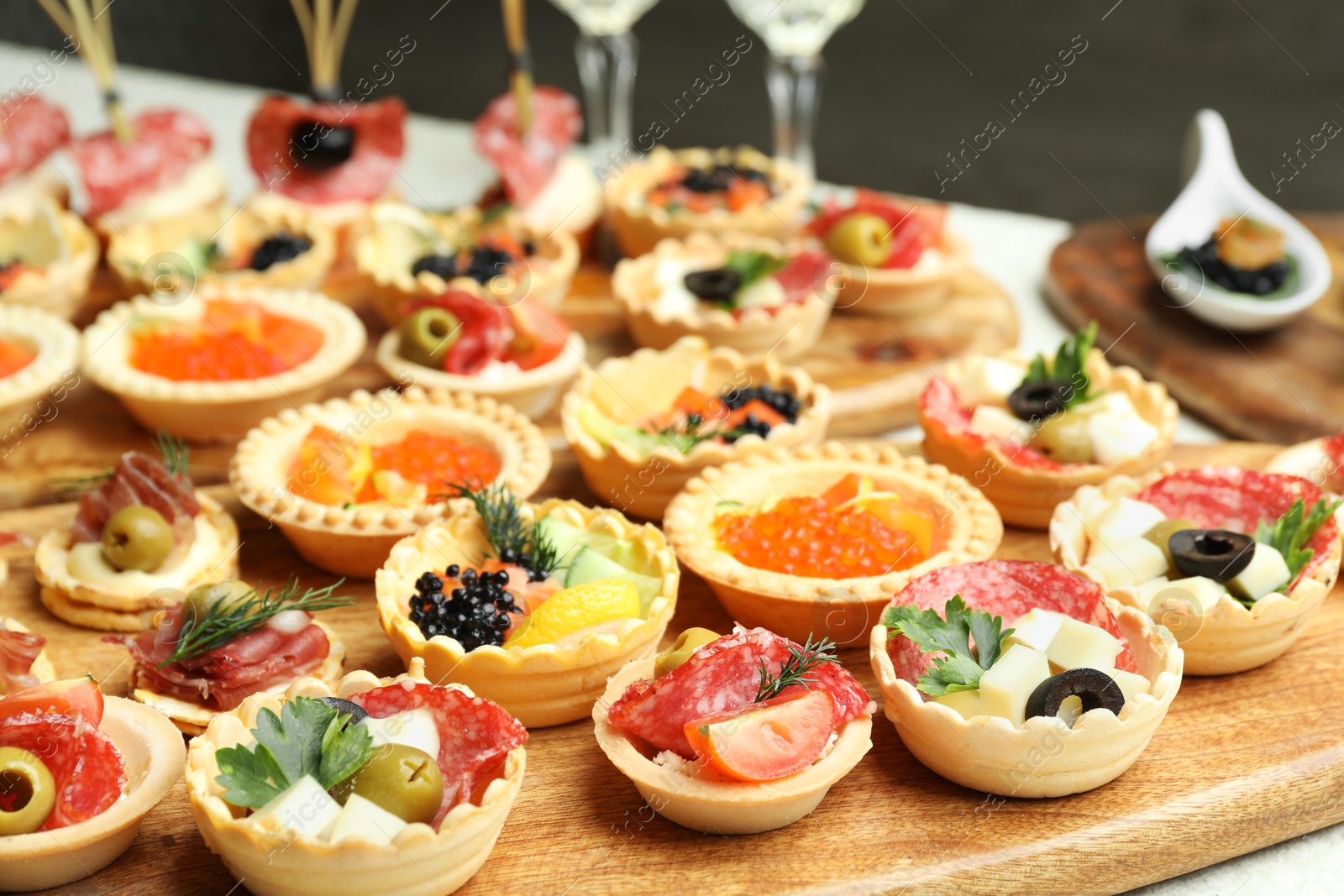 Photo of Many different tasty canapes and wine on white table, closeup