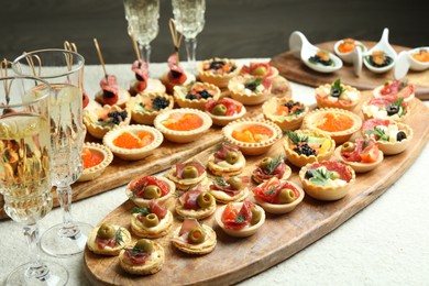 Photo of Many different tasty canapes and wine on white table