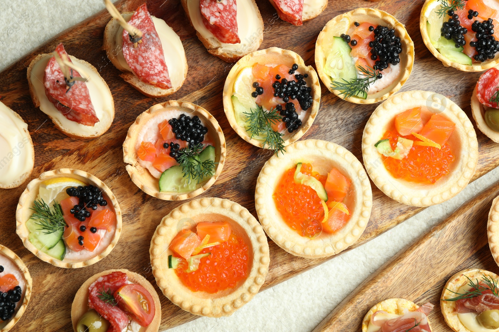 Photo of Many different tasty canapes on white table, flat lay