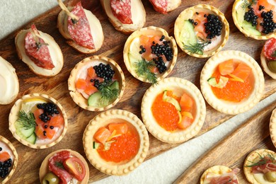 Photo of Many different tasty canapes on white table, flat lay