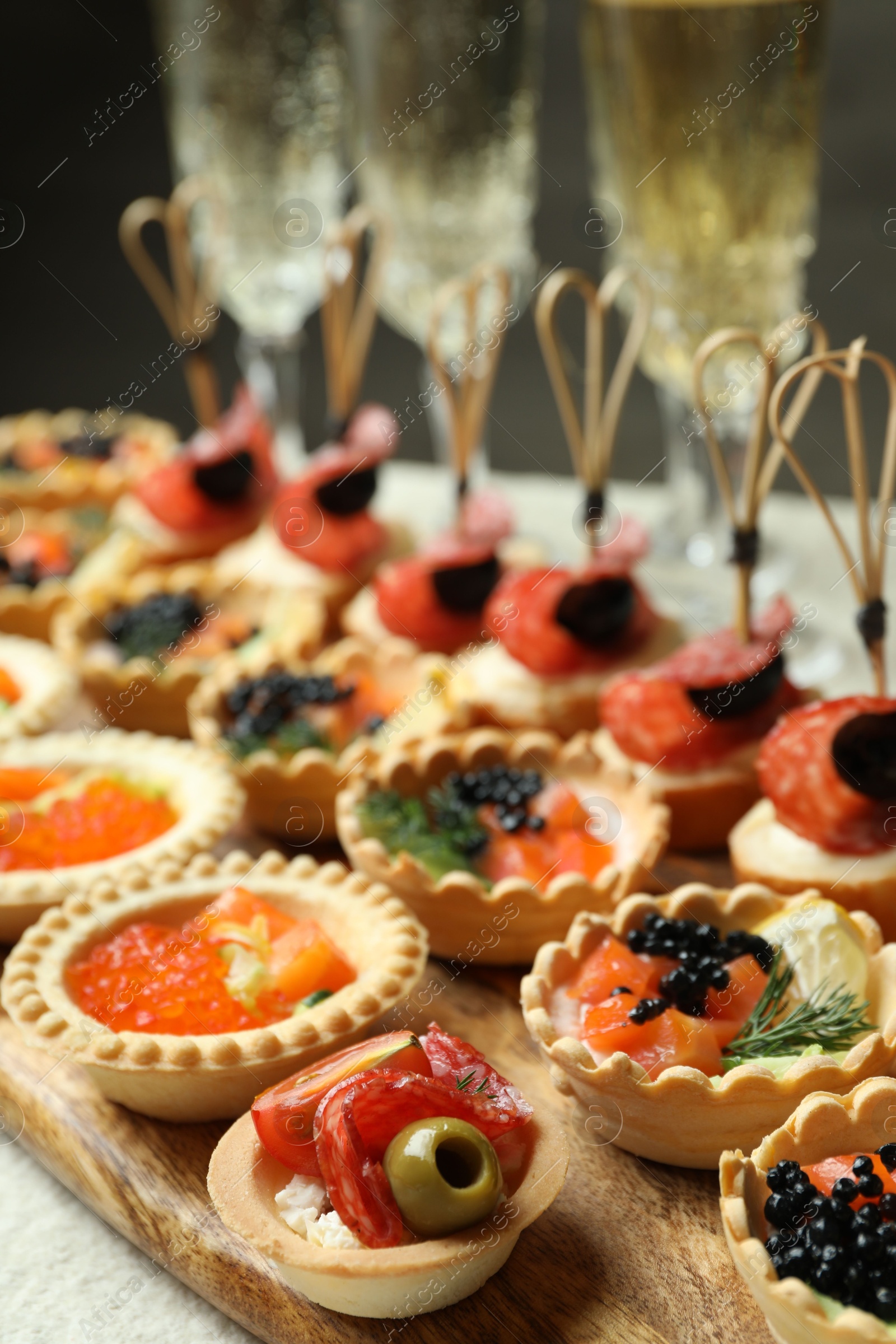 Photo of Many different tasty canapes and wine on white table, closeup