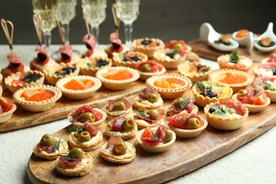 Photo of Many different tasty canapes and wine on white table