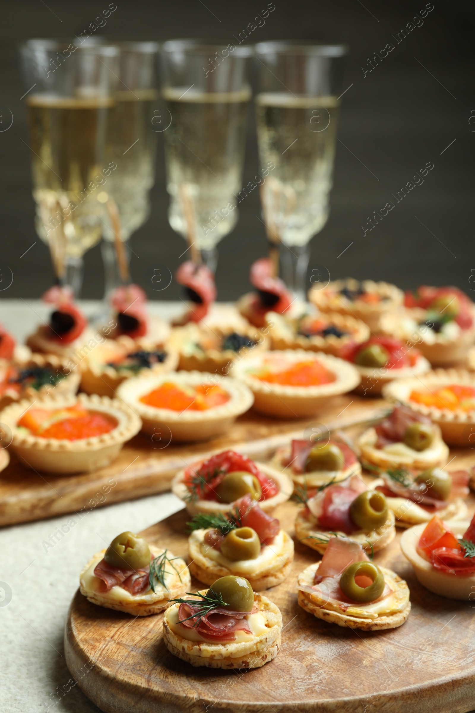 Photo of Many different tasty canapes and wine on white table, closeup