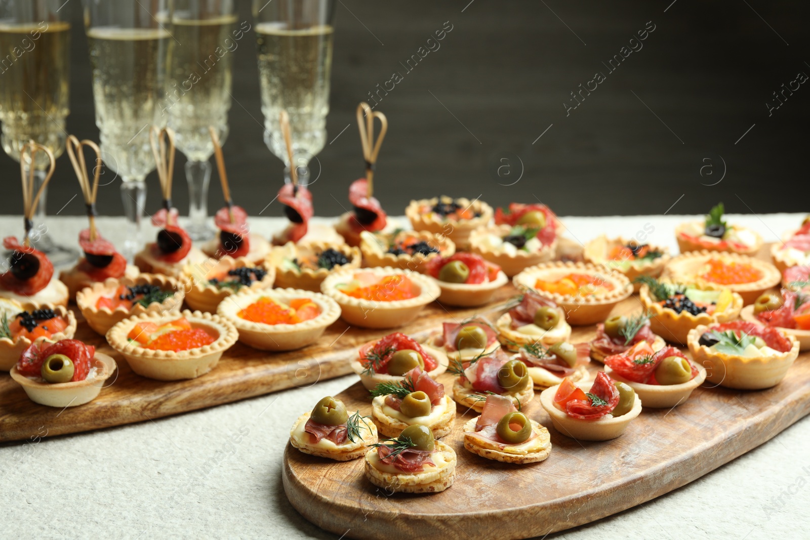 Photo of Many different tasty canapes and wine on white table