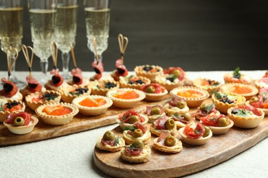 Photo of Many different tasty canapes and wine on white table