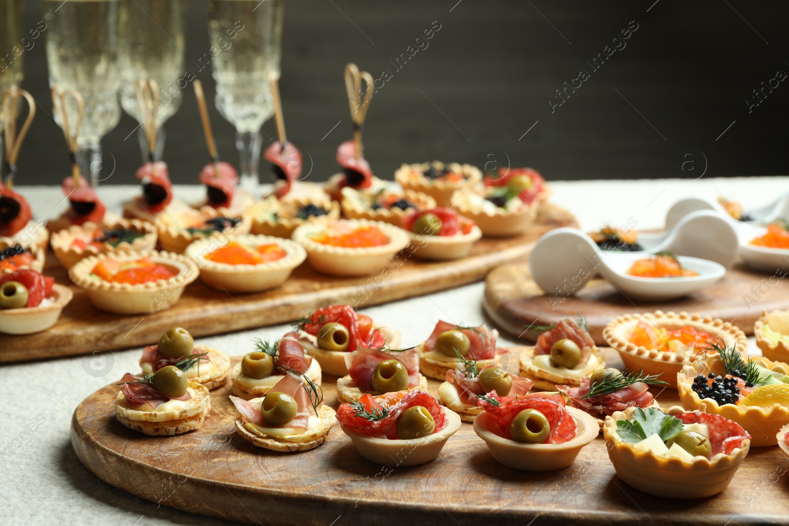 Photo of Many different tasty canapes and wine on white table