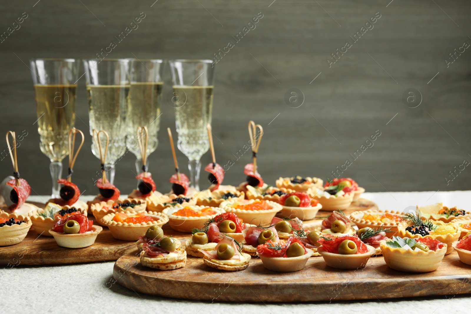 Photo of Many different tasty canapes and wine on white table