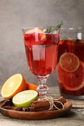 Photo of Aromatic punch drink, fresh fruits and spices on wooden table, closeup