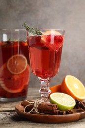 Photo of Aromatic punch drink, fresh fruits and spices on wooden table, closeup