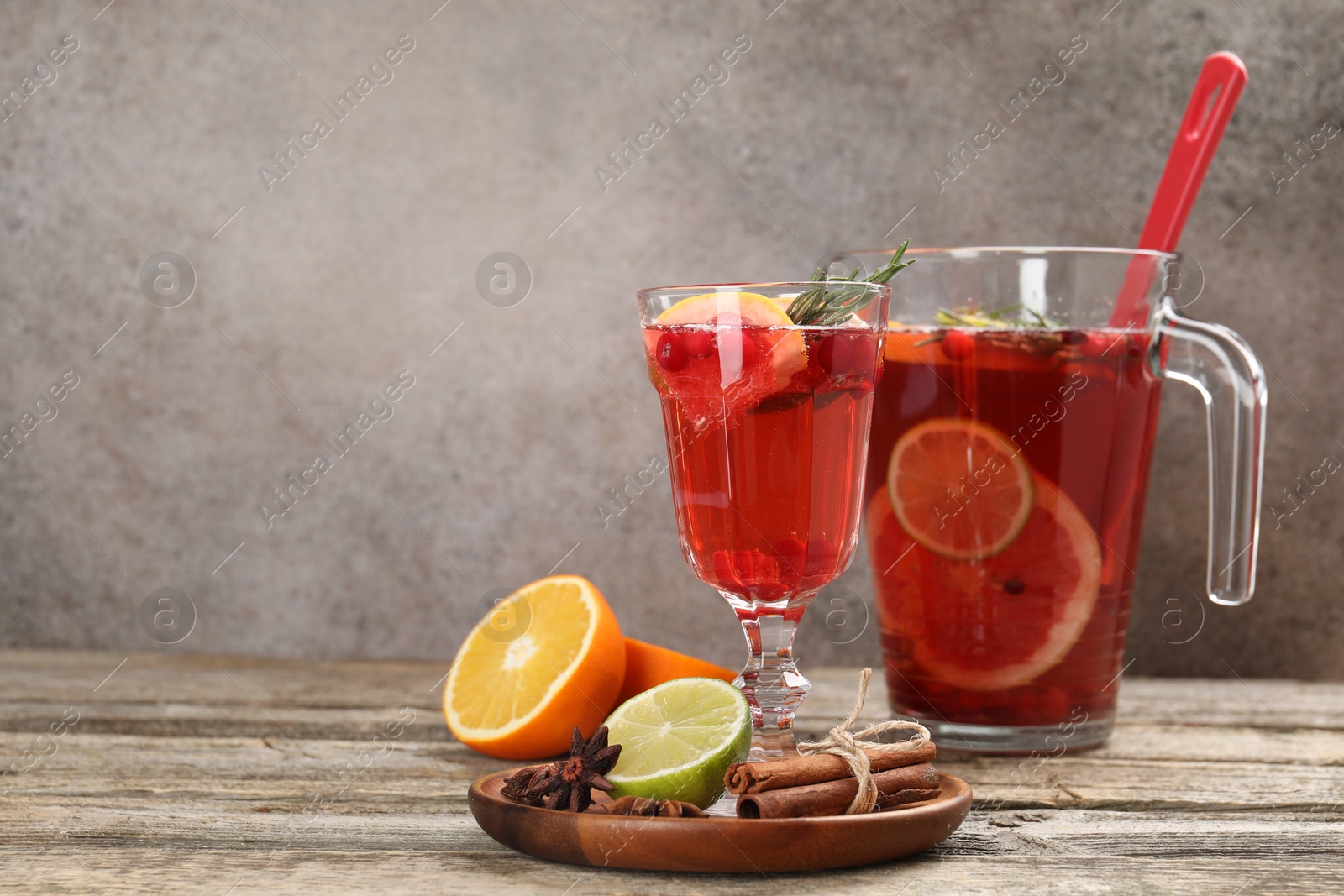 Photo of Aromatic punch drink, fresh fruits and spices on wooden table, space for text