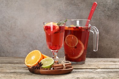 Photo of Aromatic punch drink, fresh fruits and spices on wooden table