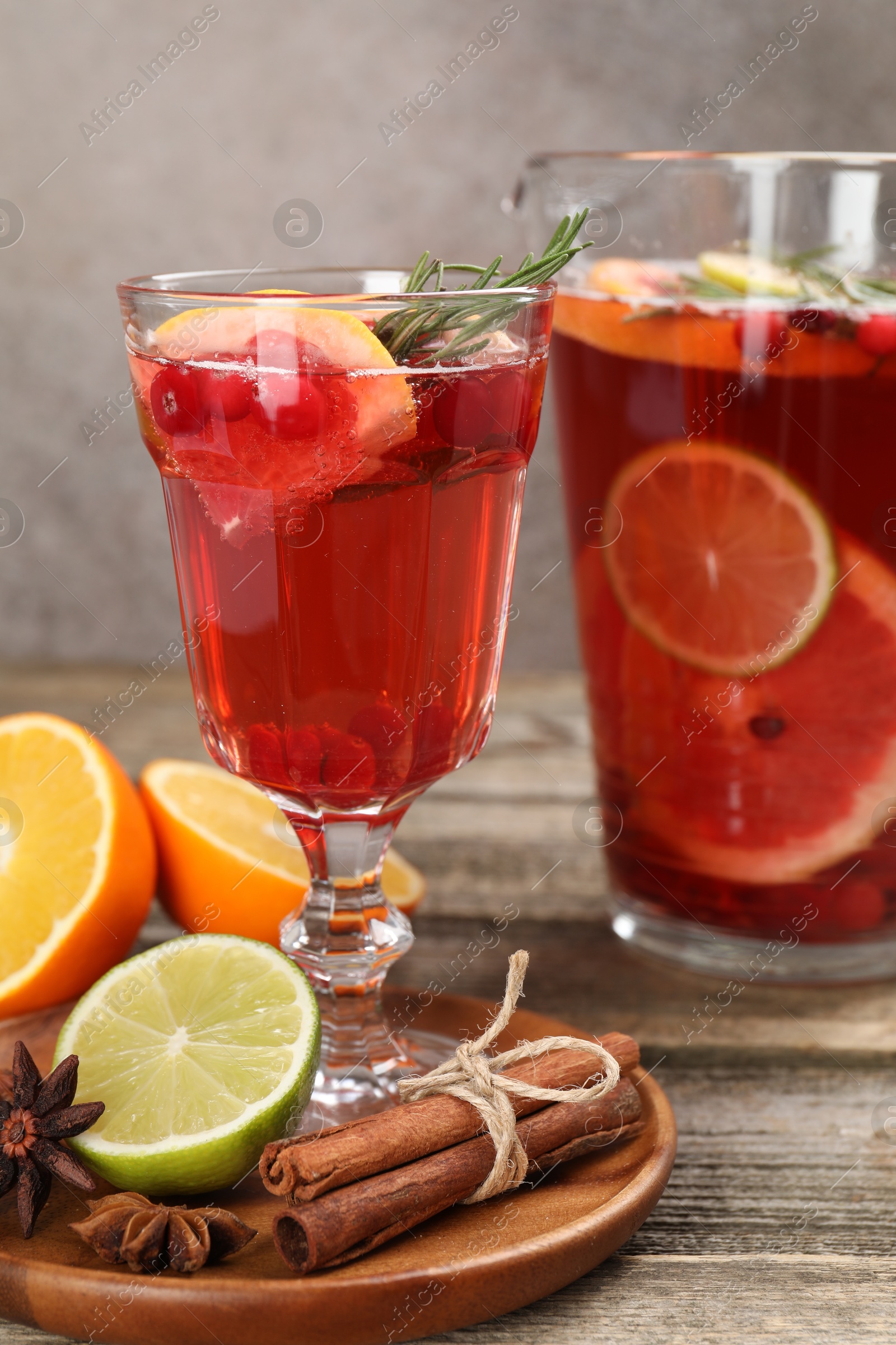 Photo of Aromatic punch drink, fresh fruits and spices on wooden table, closeup