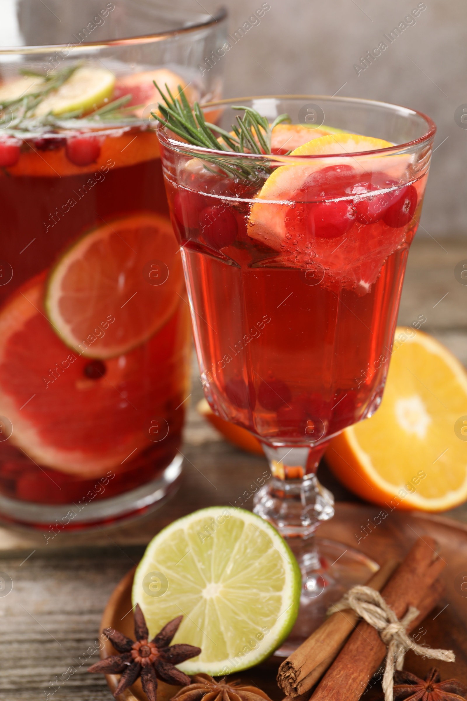 Photo of Aromatic punch drink, fresh fruits and spices on wooden table, closeup