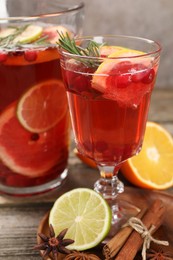 Photo of Aromatic punch drink, fresh fruits and spices on wooden table, closeup