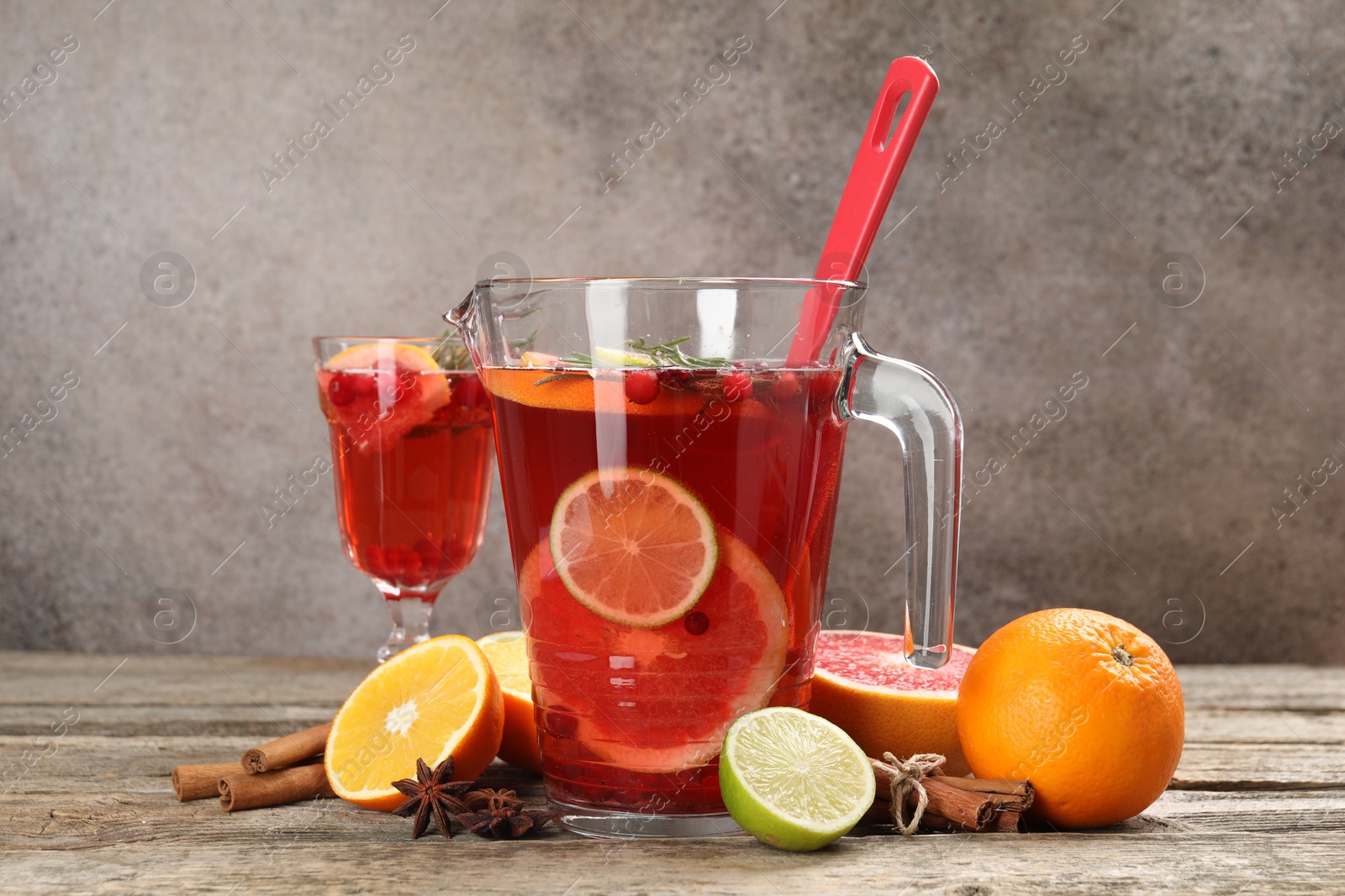 Photo of Aromatic punch drink, fresh fruits and spices on wooden table