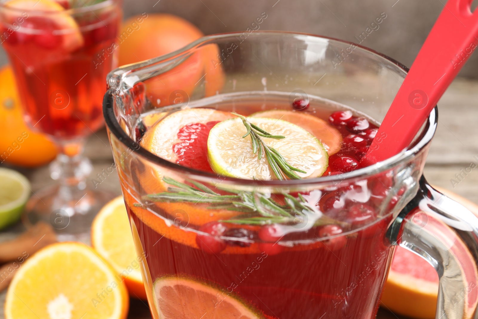 Photo of Aromatic punch drink in glass jug on table, closeup