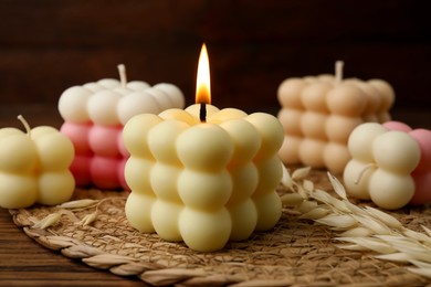 Photo of Different stylish bubble candles on wooden table, closeup