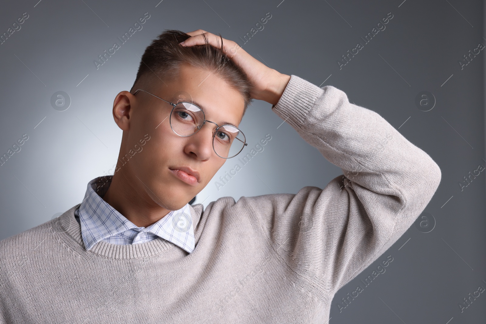 Photo of Handsome young man with stylish haircut on grey background