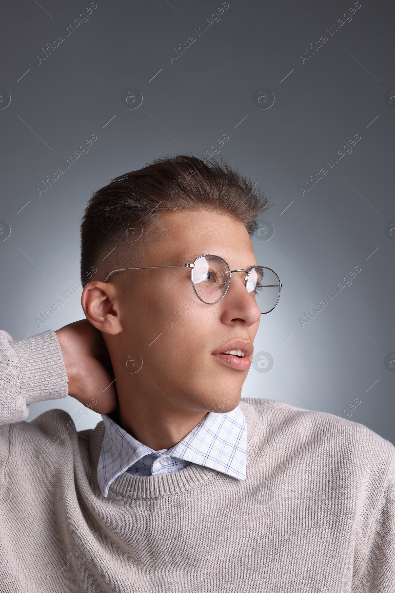 Photo of Handsome young man with stylish haircut on grey background