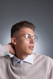 Photo of Handsome young man with stylish haircut on grey background