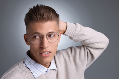 Photo of Handsome young man with stylish haircut on grey background