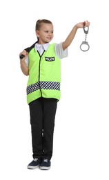 Photo of Little girl with baton and handcuffs pretending to be policewoman on white background. Dreaming of future profession