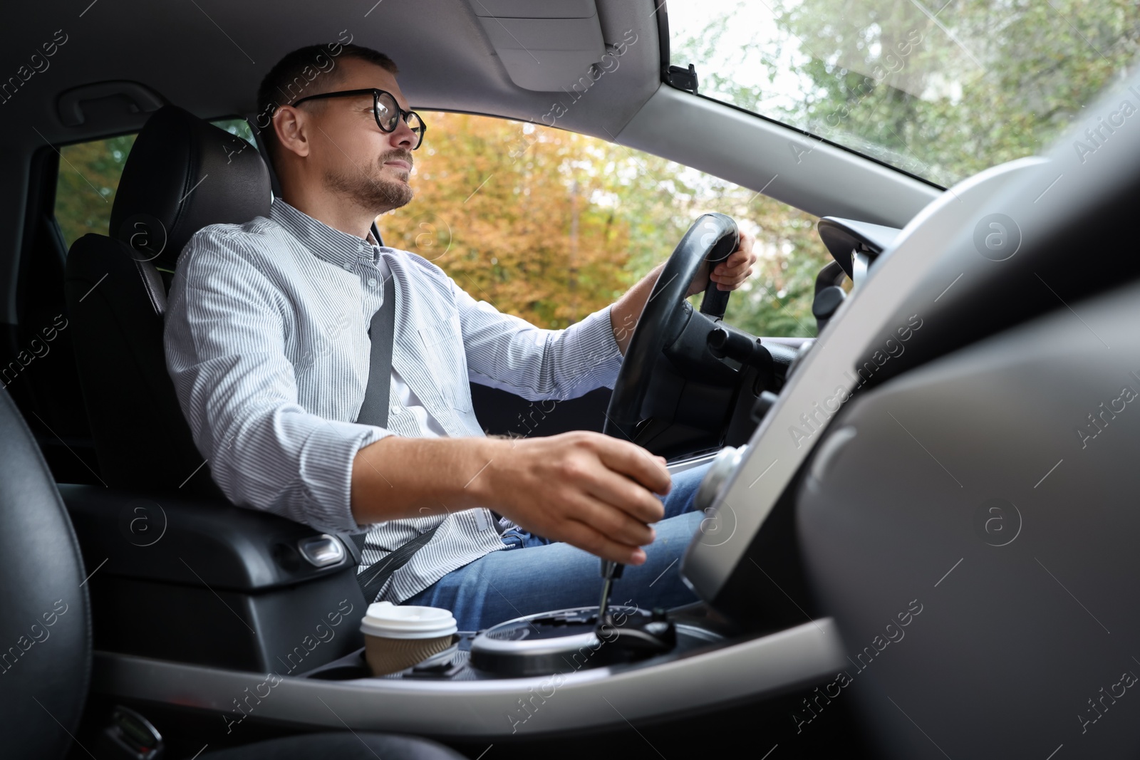 Photo of Man driving modern car, low angle view