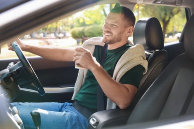 Photo of Man with cup of coffee driving modern car