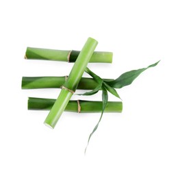 Pieces of decorative bamboo plant and green leaves isolated on white, top view