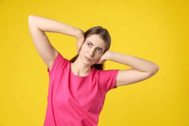 Photo of Woman covering her ears on dark yellow background