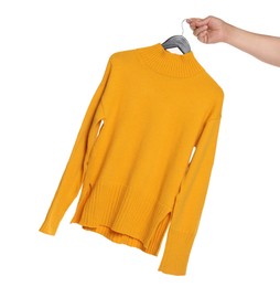 Photo of Woman holding hanger with orange sweater on white background, closeup