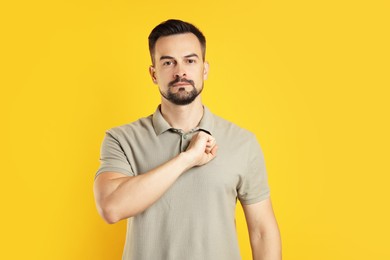 Photo of Man making promise on orange background. Oath gesture