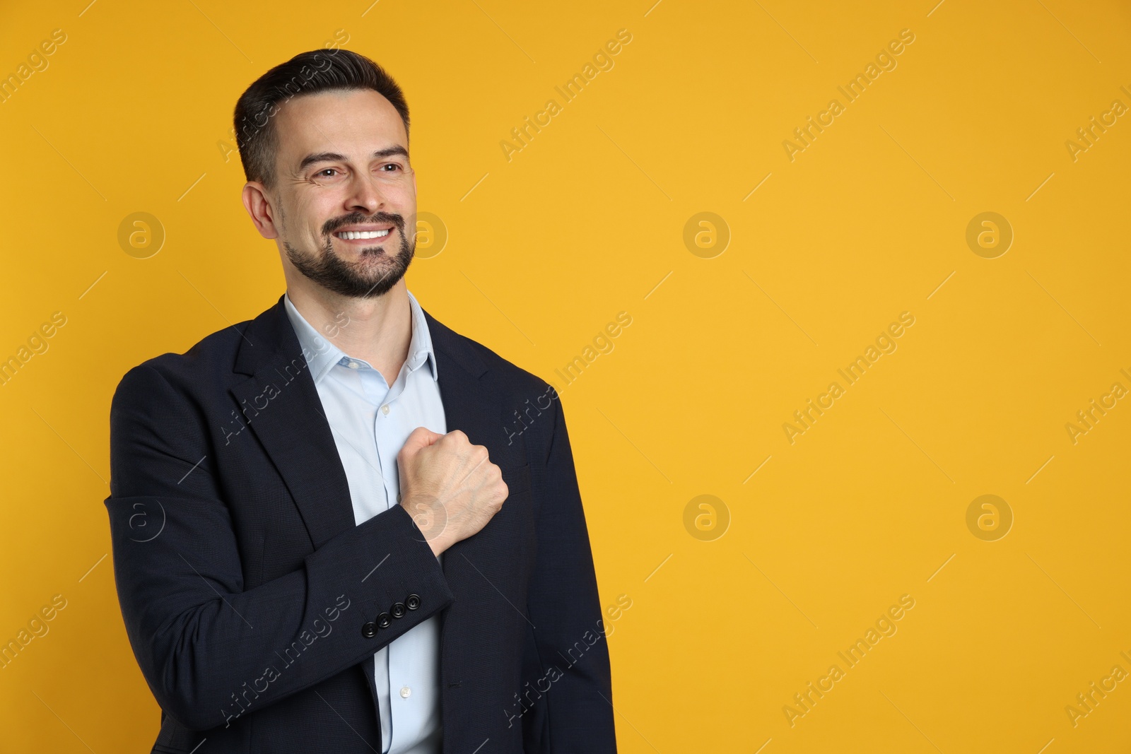 Photo of Man making promise on orange background, space for text. Oath gesture