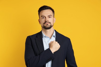 Photo of Man making promise on orange background. Oath gesture