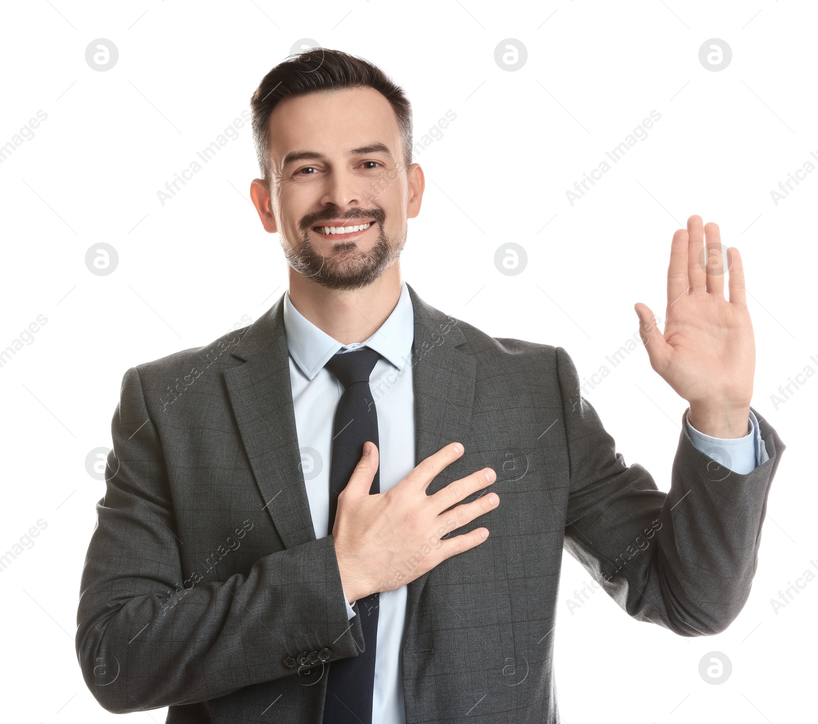 Photo of Man making promise with raised hand on white background. Oath gesture