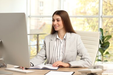 Photo of Banker working on computer at table in office