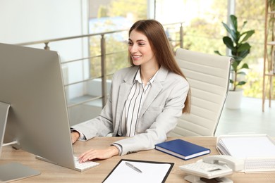 Photo of Banker working on computer at table in office