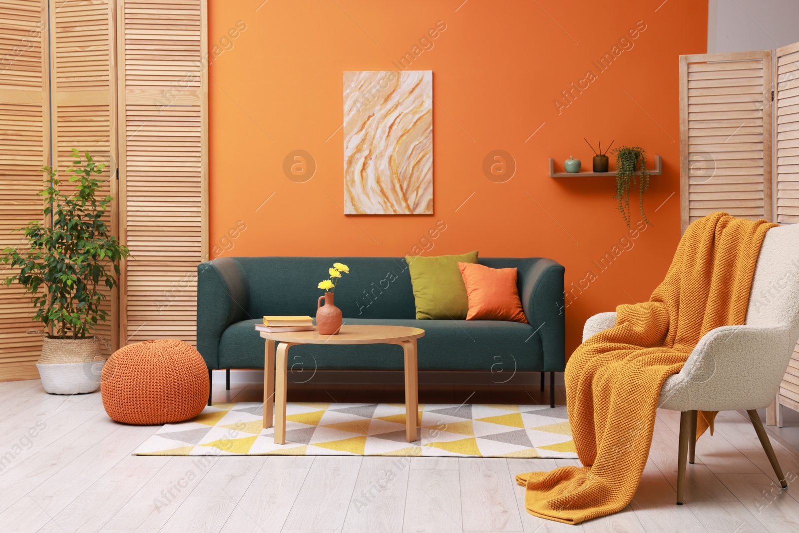 Photo of Stylish living room interior with comfortable sofa near orange wall