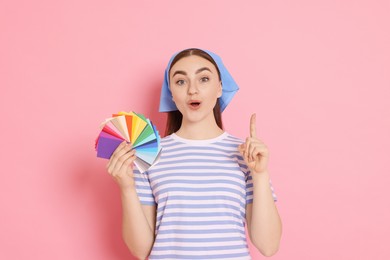 Photo of Portrait of young decorator with color palettes on pink background