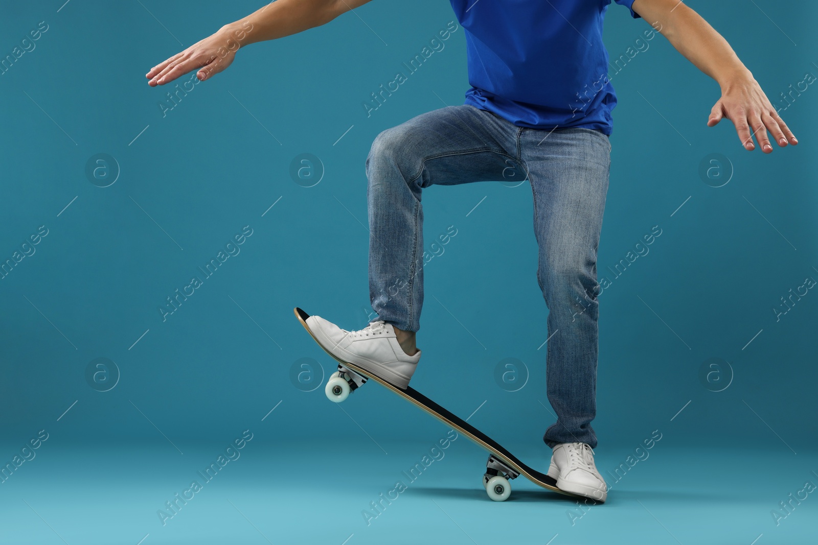 Photo of Man with skateboard on light blue background, closeup. Space for text