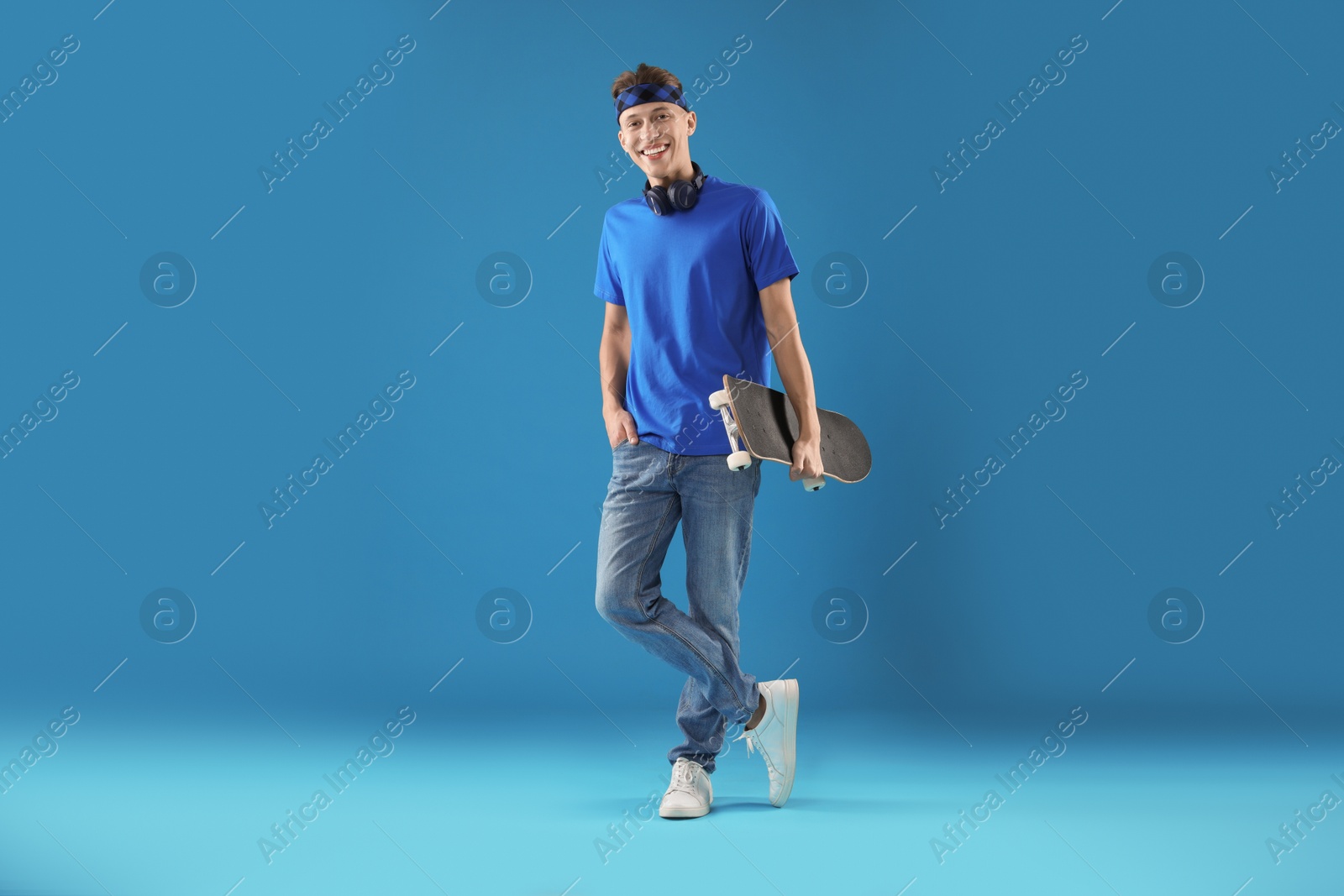 Photo of Happy man with skateboard on light blue background