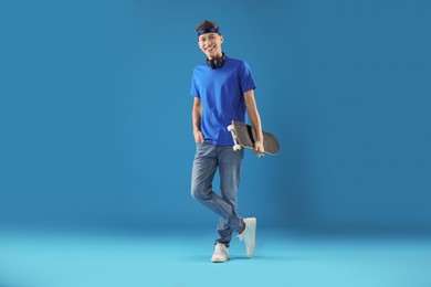 Photo of Happy man with skateboard on light blue background